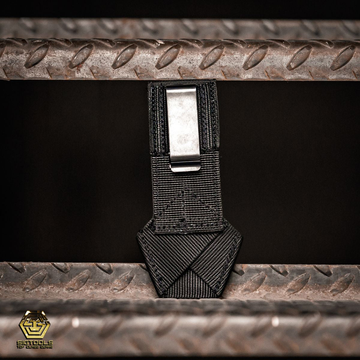 A back view of the Badger Gun Loop in black, showcasing the clip , an ideal compact tool belt accessory, designed for securing a gun or similar tool.