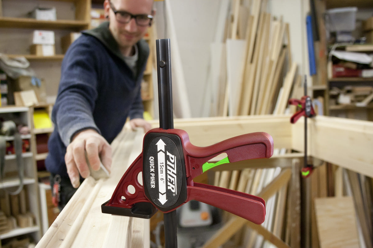 Piher Quick Clamp demonstrating one-handed operation and 150kg clamping pressure for secure woodworking.