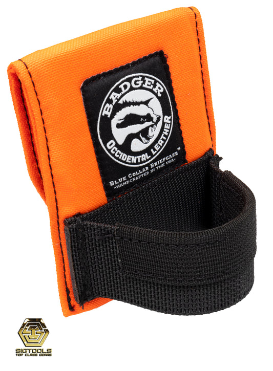 A side view of A high-visibility orange Badger hammer loop designed to secure a hammer or similar tool for easy access and convenience while working.